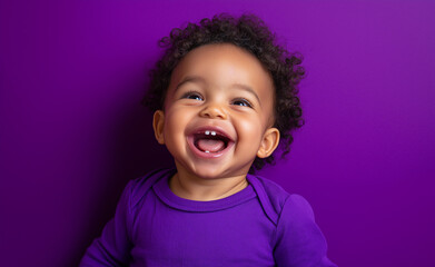 Happy toddler smiling in a purple shirt against a vibrant purple background, radiating joy and innocence.