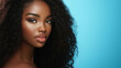 © malik - Close-up portrait of an african american woman with deep brown skin and voluminous curly hair against a vibrant blue background