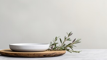 Poster - Minimalist dining setup featuring a white bowl and olive branch on a wooden platter in natural light