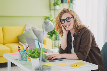 Photo of positive good mood girl wear shirt sit table use device work from home indoors workplace workspace