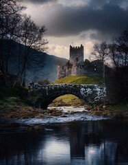 Castillo medieval en ruinas en un dia nublado, junto a un rio y  un puente