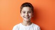 © Arceli - caucasian teen boy orange background wearing plain white tshirt smiling happy portrait
