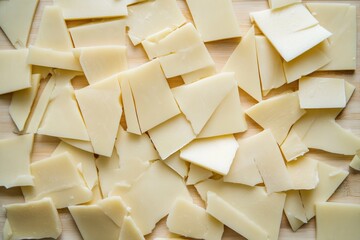 Canvas Print - Pieces of White Cheese on a Wooden Cutting Board