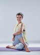 © peopleimages.com - Happy, portrait and mature woman with yoga twist on mat for zen or exercise on a white studio background. Female person, yogi or model in fitness, practice or side pose for mindfulness or pilates