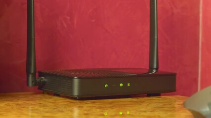 On the glossy surface of the desktop there is a router distributing the Internet via Wi-Fi and wired. Closeup. Macro. Shallow depth of field. Shot in motion