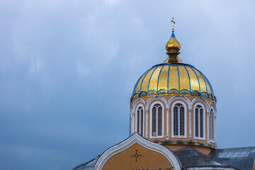 Golden dome of orthodox church gleaming under cloudy sky