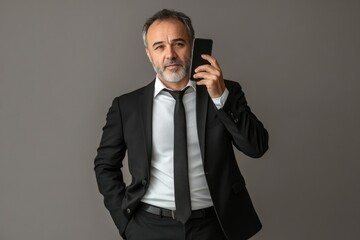 Aufkleber - A businessman holds his cell phone while dressed in a suit and tie