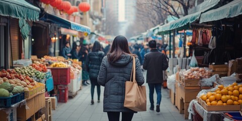 A woman is seen walking down a street past a bustling market scene