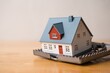 © pla2na - House in rat trap on wooden table white wall background. Real estate, property, land, rental, mortgage closing scams concept. Protect money from real estate scams when buying, rental a home.