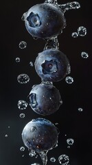 Wall Mural - Fresh blueberries splashing in water on black background