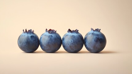 Wall Mural - Four fresh blueberries creating a diagonal line on a cream background