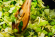 © Andrew Kornylak - Closeup of a wooden spoon mixing chopped celery, herbs, and onions in a bowl