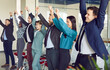 © Studio Romantic - Overjoyed office diverse employees workers showing hands up to recommend good quality company service. Happy multiethnic colleagues celebrate shared business success or victory in office, achievement