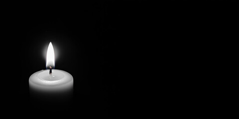 Wall Mural - Single candle burning brightly in darkness against dark black and white background with copy space. Funeral and remembrance concept.