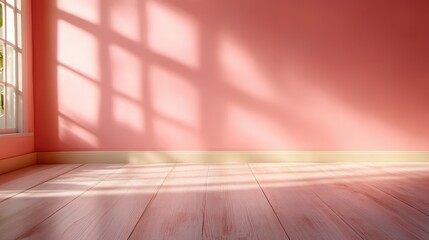 A simple room featuring pink walls and a wooden floor, gracefully lit by large window panes casting soft shadows, creating a calm, inviting space.