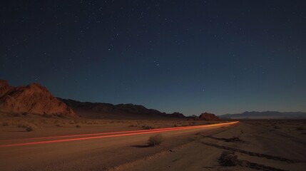 The faint glow of the light trails mirrors the ling stars above creating a picturesque scene in the desert.