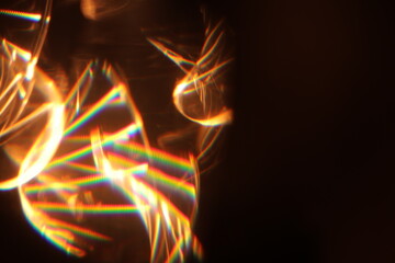Wall Mural - golden flames light leak on black background.