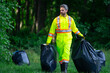 © Volodymyr - Volunteer man picking plastic trash for cleaning the nature. Clean up garbage outdoor. Ecology concept. Environment Day. Save earth. Recycling bin garbage. Ecology. Environmental care.