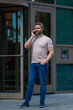 © Volodymyr - Man talking at the phone outdoor. Hispanic man in t-shirt talking on cell phone. Business man talking on the phone on NY skyline. Guy talking by mobile phone. Businessman in street holding smartphone.