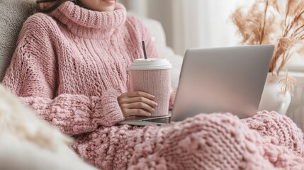 Poster - A woman is sitting on a couch with a laptop and a cup of coffee