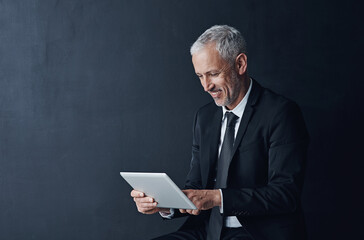 Poster - Employee, man and smile on tablet in studio on internet or website, news and stock exchange on black background. Mature person, mockup space and online updates for economy, market share and trading
