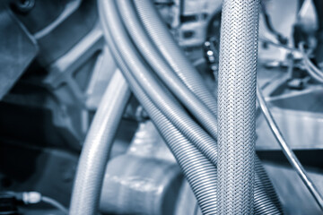 Close up of car engine with tubes and cables in blue tones