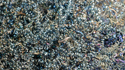 Aufkleber - A pile of metal shavings with a metallic sheen. The shavings are scattered and appear to be from a grinding process
