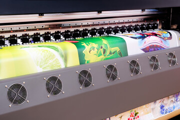 Poster - A large printer with a green lime and a green leaf on it. The printer is black and silver