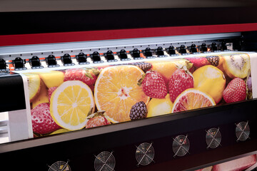 A large screen with a colorful fruit print. The fruits include oranges, strawberries, and kiwis