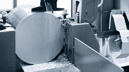 Fototapete - A machine is cutting a metal object. The machine is black and silver. The object being cut is round, Industrial metalworking concept background