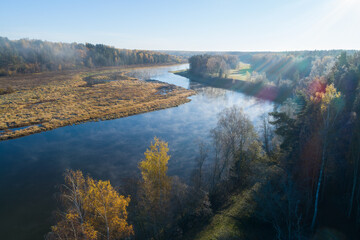 Aufkleber - A river with trees on both sides and a foggy mist in the air. The mist is creating a serene and peaceful atmosphere