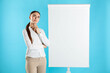 © New Africa - Thoughtful woman near flip chart on light blue background. Mockup for design