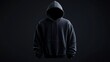 © banzeo - A black hoodie with a hood pulled up, obscuring the face of the wearer. The hoodie is isolated on a black background.