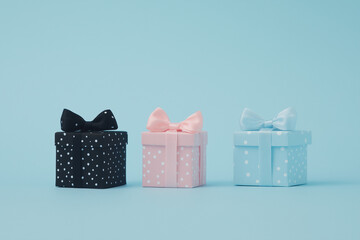 Small gift boxes of different colors and patterns arranged in a row on a white table against a blue background.	
