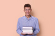 © New Africa - Young student with stack of books happy about his good exam result on beige background