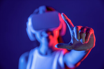 Female standing surrounded by neon light wear VR headset connecting metaverse, futuristic cyberspace community technology, spreading index and thumb finger interacting virtual object. Hallucination.