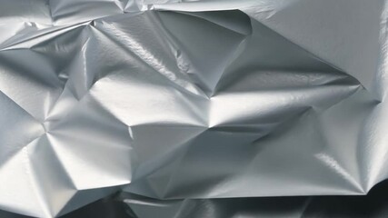 Poster - The shiny surface of crumpled aluminum foil creates a striking abstract texture, catching and reflecting light in unique patterns and folds, perfect for creative projects.