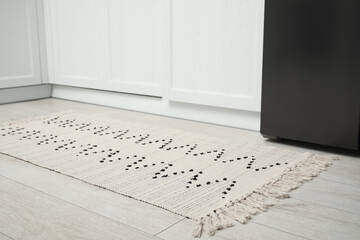 Canvas Print - Stylish soft rug on wooden floor in kitchen