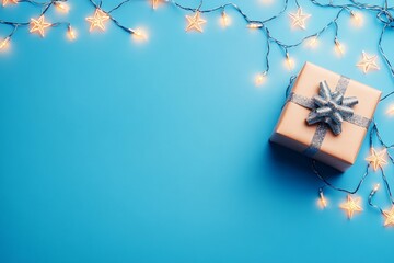 A gold-wrapped Christmas present with a glittery blue bow, placed on a blue background. Warm star-shaped fairy lights add a festive glow to this minimalist holiday composition.