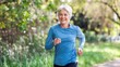 © Ben Trobat - Elderly woman jogging outdoors in a park with a joyful expression