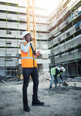 Poster - Black man, civil engineer and talking with phone call on site for communication, construction or maintenance in city. Young African, architect or builder with mobile smartphone for industrial job