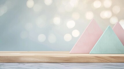 Poster - Pink and turquoise triangles sit on a light wooden shelf against a soft-focus bokeh background, creating a minimalist and modern aesthetic