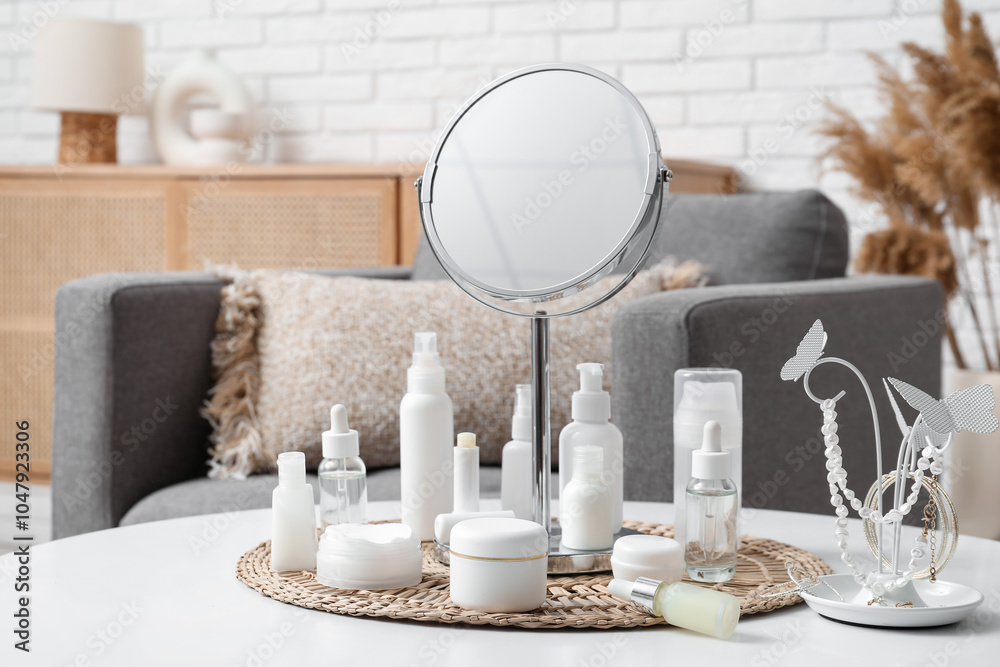 Different cosmetic products, accessories and mirror on table in room