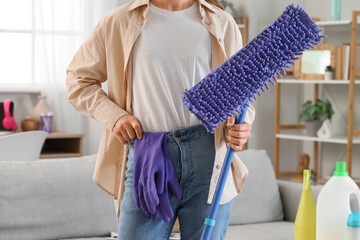 Young woman with floor mop in  room