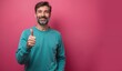 © Yury - Cheerful mature man with thumbs up gesture against pink background with copy space
