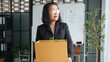 © Wanda - Senior business asian woman mature retire from work elderly employee packing the box and leaving the office