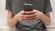 © Irina - Hands of a young man sending a message via mobile phone on a smartphone