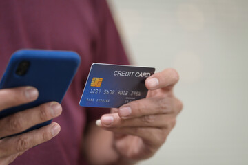 Wall Mural - Close-up of a man's hand holding a bank credit card, highlighting online services for lending and access to credit,demonstrating financial convenience and flexibility for secure digital transactions