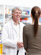 © peopleimages.com - Pharmacist, customer and advice for wellness, help or medicine as drugstore, chemist or pharmacy. Medical professional, male person and woman for prescription or info in dispensary as support or care