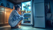 © Anoo - A woman in pajamas squats by the open refrigerator at night, enjoying a midnight snack from the cool, well-lit space filled with food